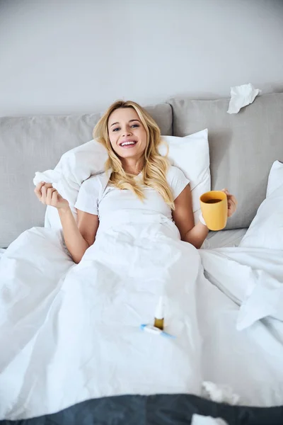 Positief verrukt vrouw drinken thee in haar bed — Stockfoto