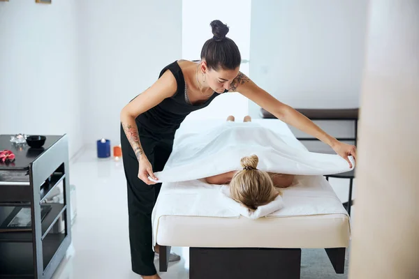 Terapeuta de massagem bonita terminou o tratamento de aroma no centro de spa — Fotografia de Stock