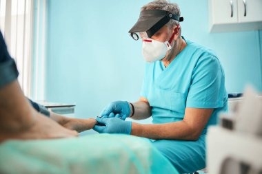 Pediatri kliniğinde çalışan ciddi kıdemli bir adam.