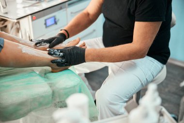 Hastanın bacaklarına masaj yapan özenli pediatrist.