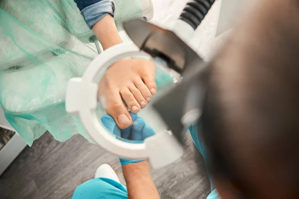 Trabalhador médico atento olhando através de lupa — Fotografia de Stock