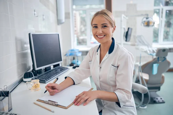 Happy female dentist working in modern office — Stock fotografie