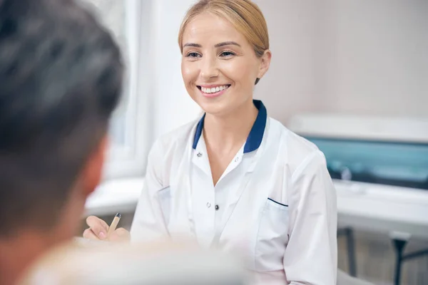 Dentiste féminine gaie lors d'un rendez-vous avec un homme à la clinique — Photo