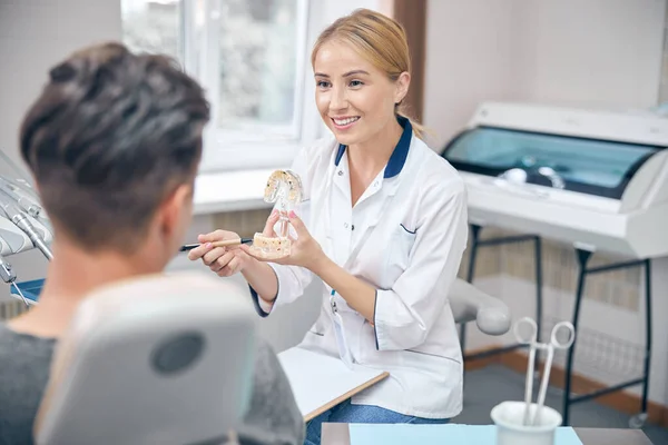 Jolly female dentist during man visit in office — Stock fotografie