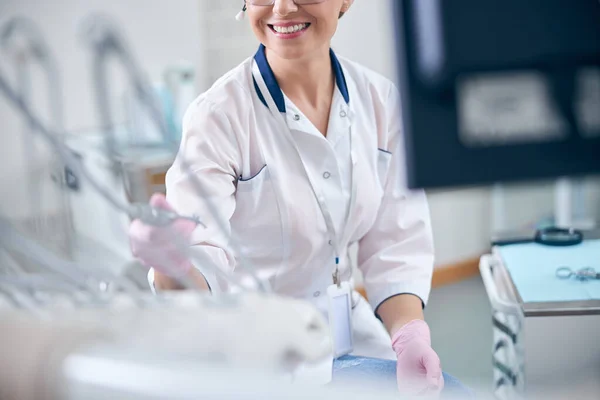 Χαρούμενη γυναίκα οδοντίατρος που εργάζεται με σύγχρονο εξοπλισμό — Φωτογραφία Αρχείου
