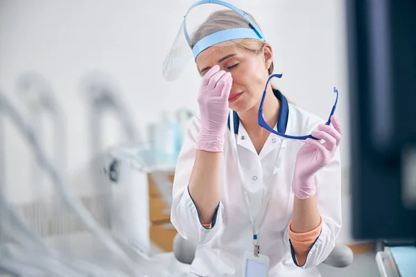 Γυναίκα οδοντίατρος αισθάνεται κουρασμένος μετά τις διαδικασίες στο γραφείο — Φωτογραφία Αρχείου