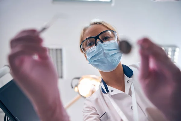 Mladá zubní lékařka ošetřující pacienta v ordinaci — Stock fotografie