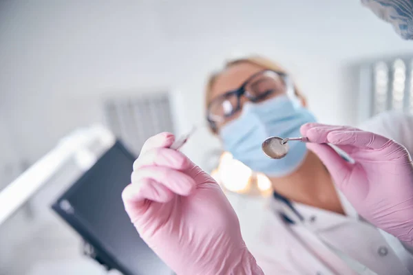 Dentista femenina usando instrumentos durante el tratamiento del paciente — Foto de Stock