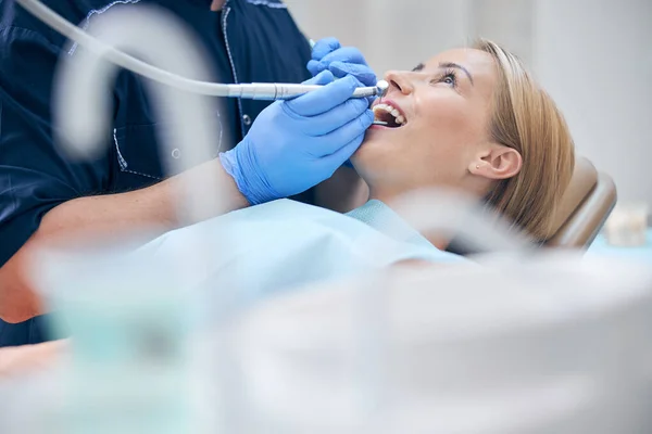 Οδοντίατρος θεραπεία νεαρή ελκυστική γυναίκα με μηχανή — Φωτογραφία Αρχείου