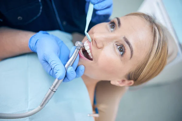 Mujer joven durante procedimientos dentales en la clínica — Foto de Stock