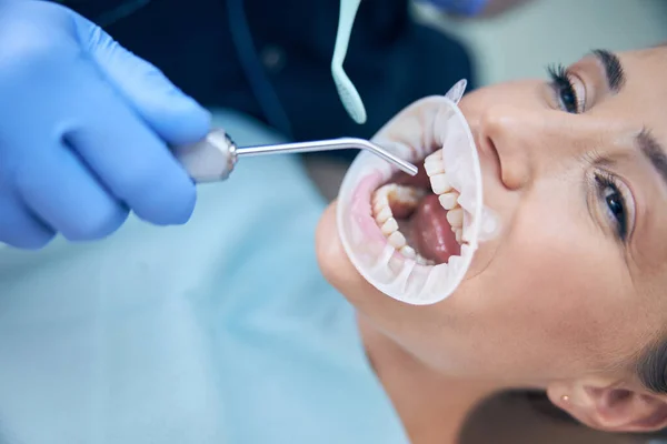 Młoda kobieta leczona zębami w klinice — Zdjęcie stockowe
