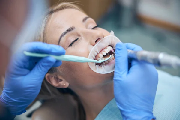 Jonge vrouw met tanden behandeld bij tandarts — Stockfoto