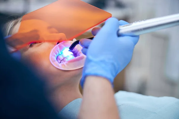 Dentista usando equipo moderno durante el procedimiento con la mujer — Foto de Stock