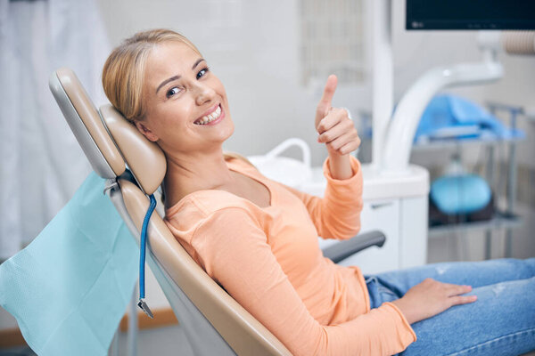Joyful young woman feeling good at dentist