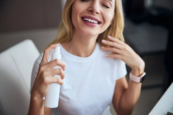 Attractive smiling woman using organic cosmetic for skin in room indoors — Stock Photo, Image