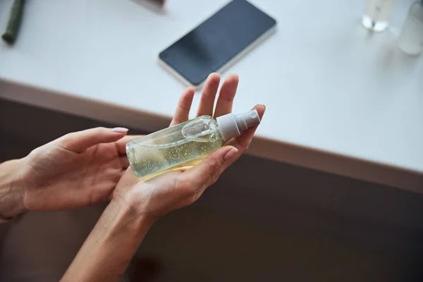 Flacon de savon avec cosmétique bio dans le bras de la femme — Photo