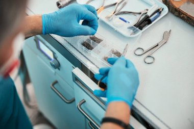 Masanın altından özel bir cihaz seçen tanınmamış bir doktorun odaklanmış görüntüsü