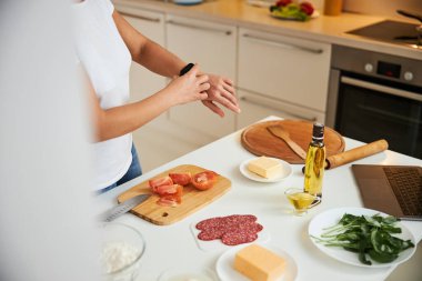 Tanımlanamayan kadın yemek yaparken saati kontrol ediyor