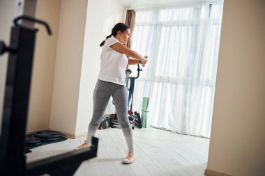 Sporcu dik pozisyonda gövdesini büküyor.