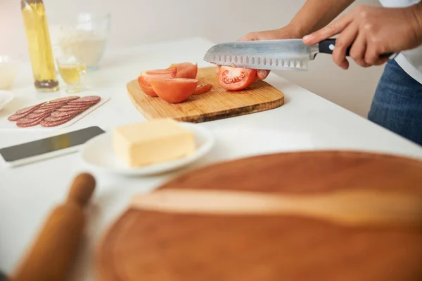 Нарізання помідорів гострим ножем на кухні — стокове фото