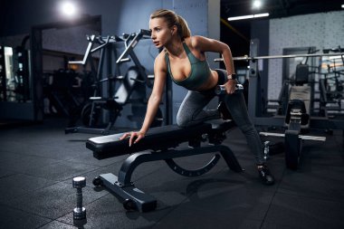 Sportsperson bankta eğiliyor ve egzersiz yapıyor.