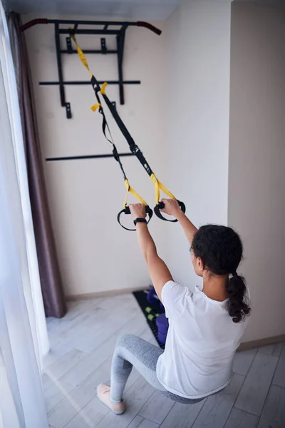 Sporty lady doing the suspension training exercise — Stock Photo, Image