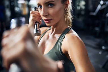 Sol kroşe sallarken dambılı olan bir kadın.