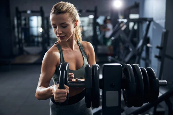 Female returning a disk weight to its place — Stock Photo, Image