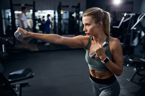 Entschlossene Sportlerin mit Handgewicht einen kräftigen Schlag — Stockfoto