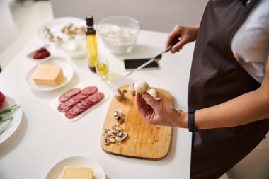 Yetenekli şefin elindeki çiğ taze mantar.