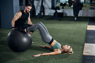 Sportsperson bir fitness topuna kıvrım yapıyor.