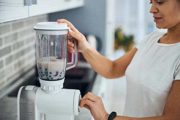 Huisvrouw met behulp van het keukenapparaat voor het maken van een smoothie — Stockfoto