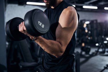 Güçlü erkek kol bir el ağırlığı kaldırıyor.