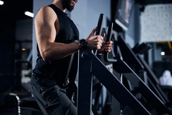 Manlig idrottsman flyttar handtagen på en styrketräningsmaskin — Stockfoto