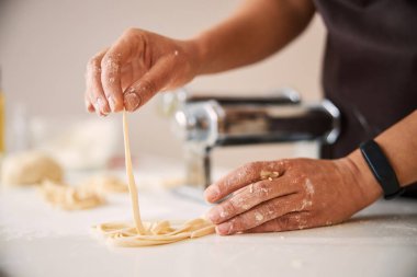 Yemek pişirirken ince çizgili hamur topluyorum.
