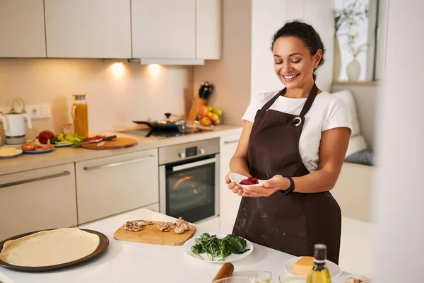 Прекрасна дама захоплюється харчовими інгредієнтами на кухні — стокове фото