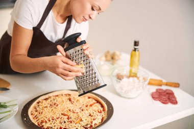 Pizzanın üstüne peynir katmanı yapıyorum.