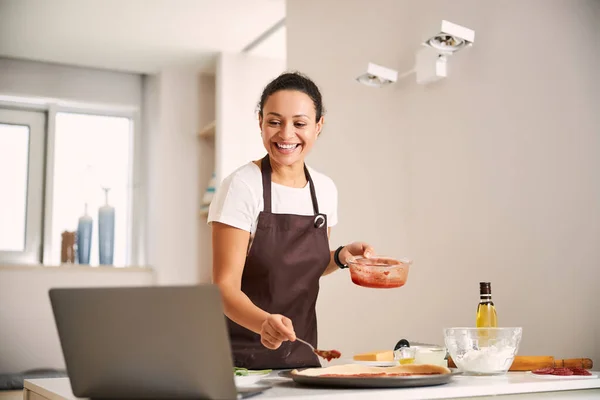 Tevreden blogger koken voor haar moderne laptop — Stockfoto