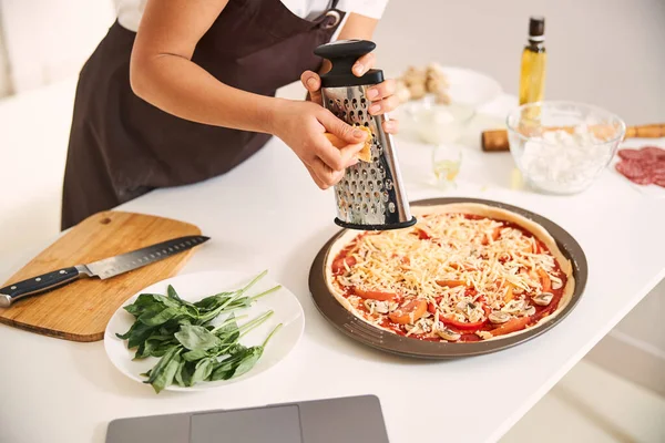 Невідома людина готує піцу біля ноутбука — стокове фото