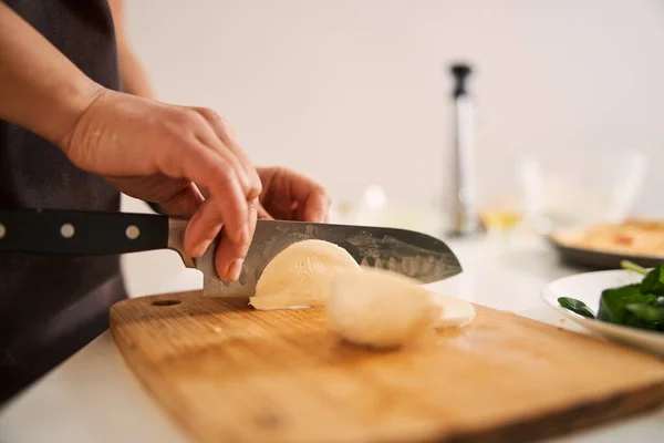 Hand with sharp knife cutting cheese close up photo — Stock Photo, Image