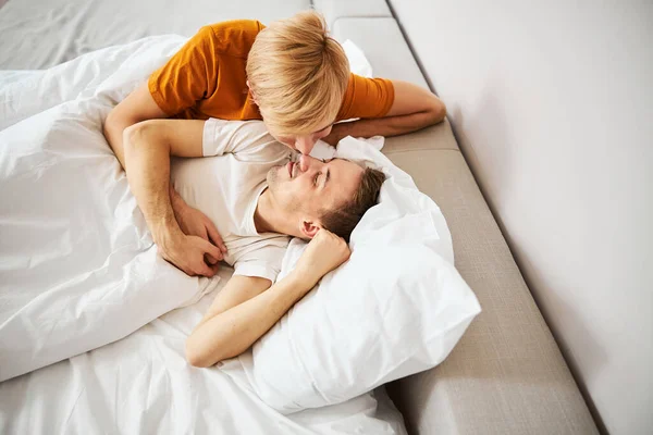 快乐的同性恋夫妇触摸着鼻子，拥抱在床上 — 图库照片