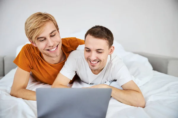 Feliz gay pareja viendo película juntos en laptop —  Fotos de Stock