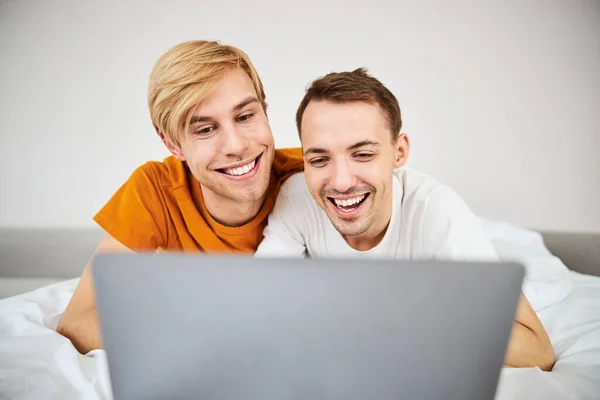 Feliz pareja homosexual viendo la película juntos en el portátil —  Fotos de Stock