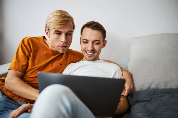 漂亮的同性恋夫妇在家里用现代笔记本电脑 — 图库照片