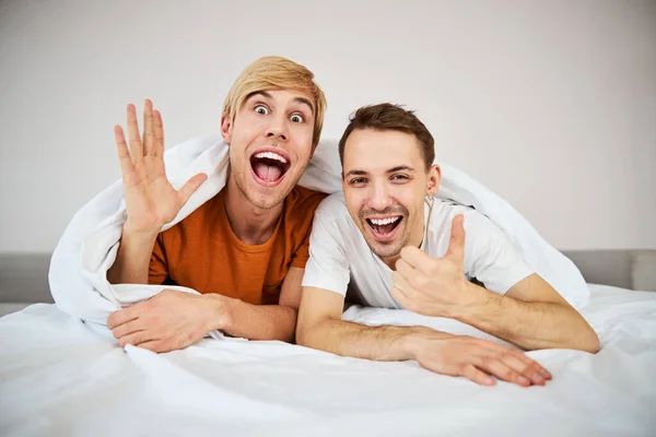 Happy homosexual couple lying in bed at home — Stock Photo, Image