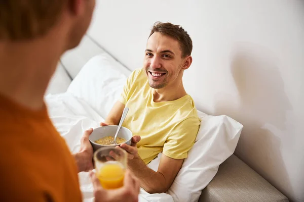 Liebender Mann bringt seinem Freund leckeres Frühstück — Stockfoto