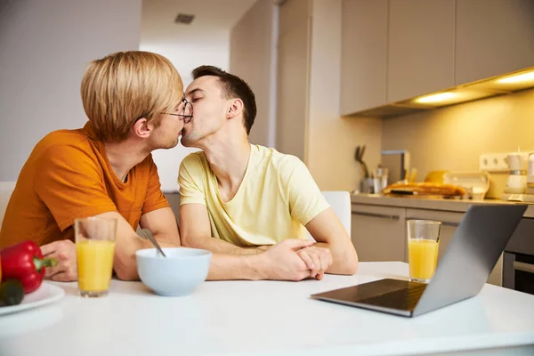 Gelukkig gay paar vasthouden handen en zoenen thuis — Stockfoto