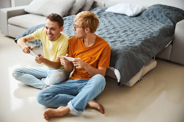 Alegre gay pareja jugando video juego en casa — Foto de Stock