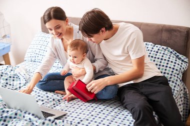 Mutlu genç ebeveynler çocuklarıyla oynuyorlar.