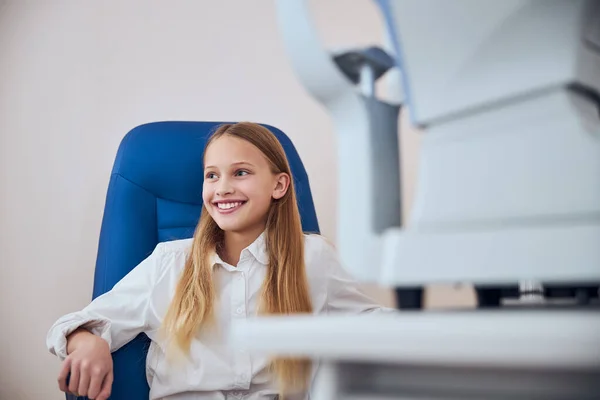 Pretty cute child sitting on the medicine chair in ophthalmologist cabinet — Stock Photo, Image